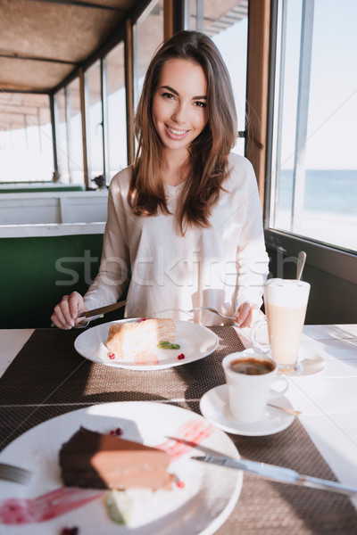 Vertical image of woman on date with coffee and cake Stock photo © deandrobot
