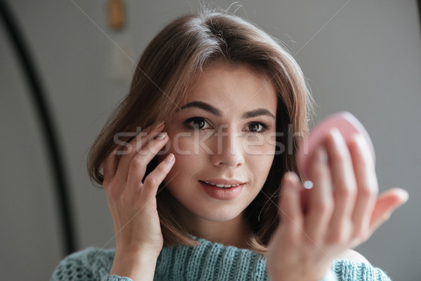 Pretty cheerful lady looking at mirror. Stock photo © deandrobot