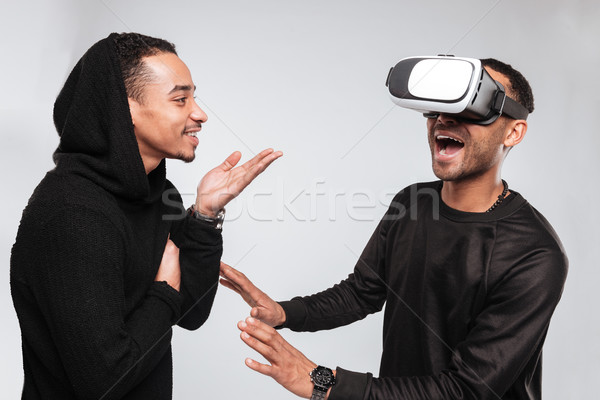 Stock photo: Two cheerful african men using 3d virtual reality device.