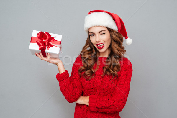 Woman in Santa's hat keeps christmas gift Stock photo © deandrobot