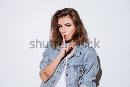 Lady dressed in jeans jacket make silence gesture. Stock photo © deandrobot