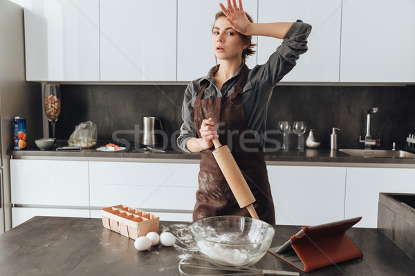 Woman standing in kitchen and cooking the dough Stock photo © deandrobot