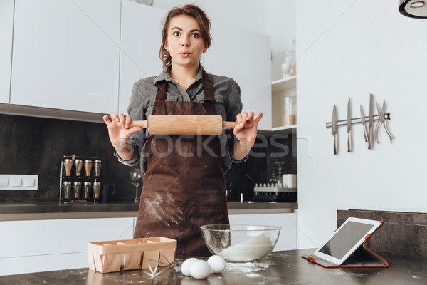 Stock photo: Beautiful woman standing in kitchen and cooking