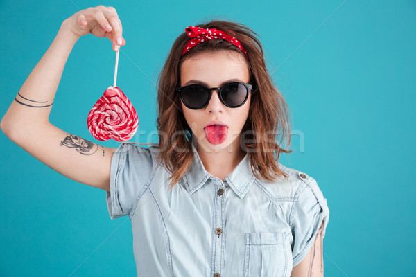 Concentrated young lady eating candy. Stock photo © deandrobot