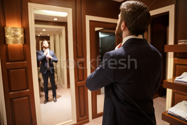 Backview image of man in suit near mirror Stock photo © deandrobot