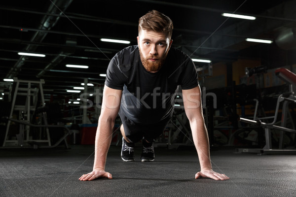 Concentrated young strong sports man make plank exercise Stock photo © deandrobot