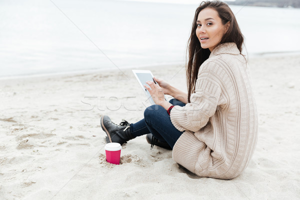 Beautiful young caucasian lady sitting outdoors at beach Stock photo © deandrobot