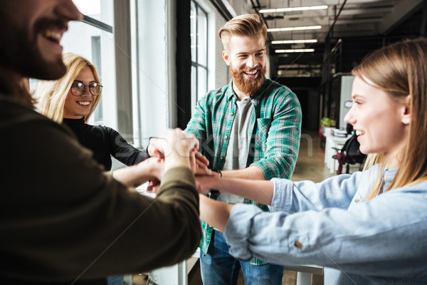 Colleagues in office holding hands of each other Stock photo © deandrobot