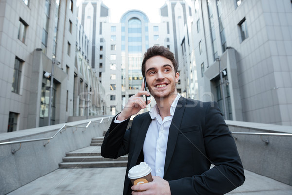 Businessman holding coffee and phone Stock photo © deandrobot