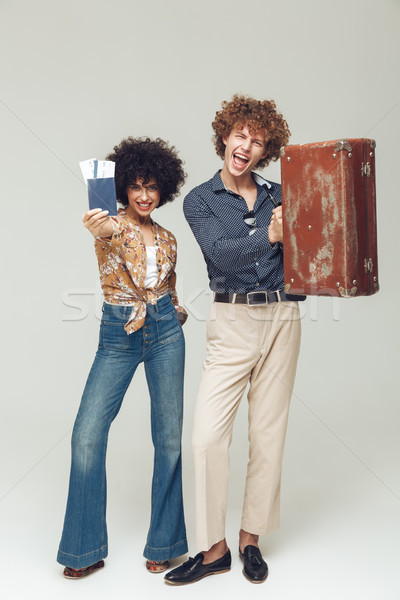 Retro loving couple holding suitcase passport and tickets. Stock photo © deandrobot