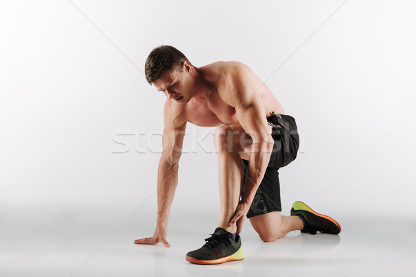 Displeased young sportsman have painful feelings in leg. Stock photo © deandrobot