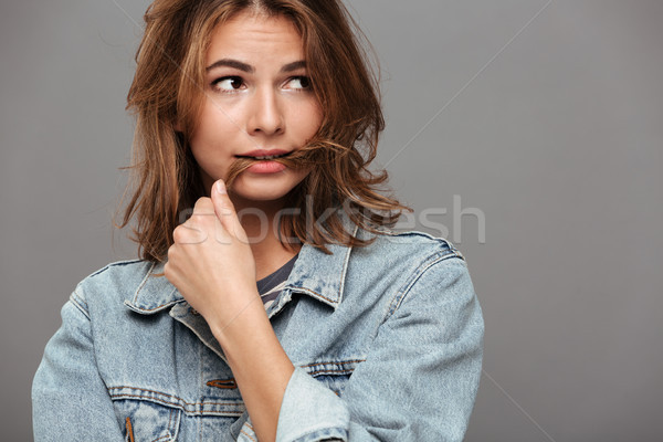 Close up portrait of a doubtful girl in denim jacket Stock photo © deandrobot