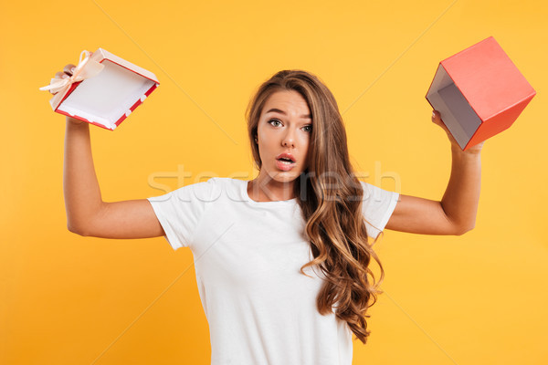 Portrait of a confused young girl showing empty gift box Stock photo © deandrobot
