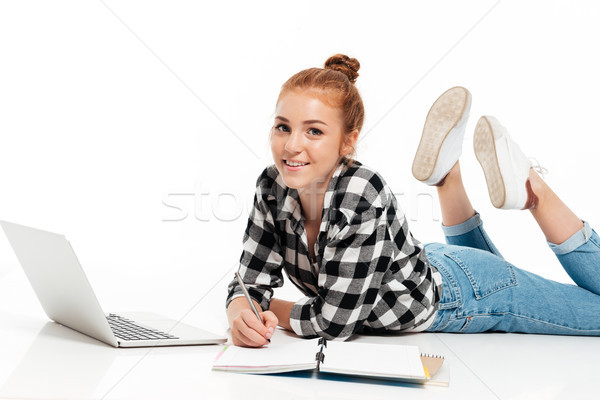 Happy ginger woman in shirt and jeans lying on floor Stock photo © deandrobot
