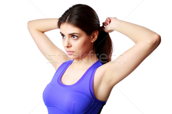 Portrait of a young beautiful sport woman making a ponytail isolated on white background Stock photo © deandrobot
