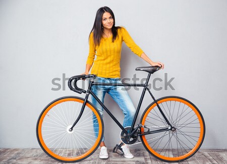 Donna sorridente piedi bicicletta ritratto grigio Foto d'archivio © deandrobot