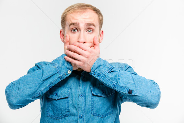 Shocked dazed man closed his mouth by hands  Stock photo © deandrobot