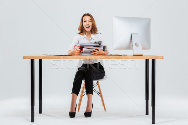 Surprised happy young businesswoman sitting at the table with pc Stock photo © deandrobot