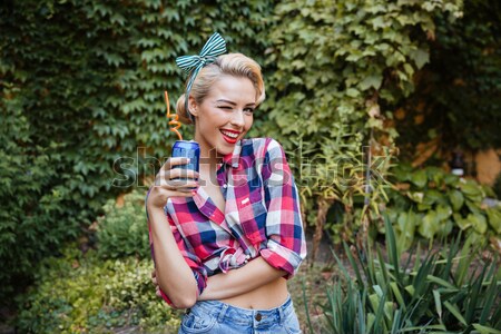 Smiling beauiful pin-up girl standing in the garden Stock photo © deandrobot