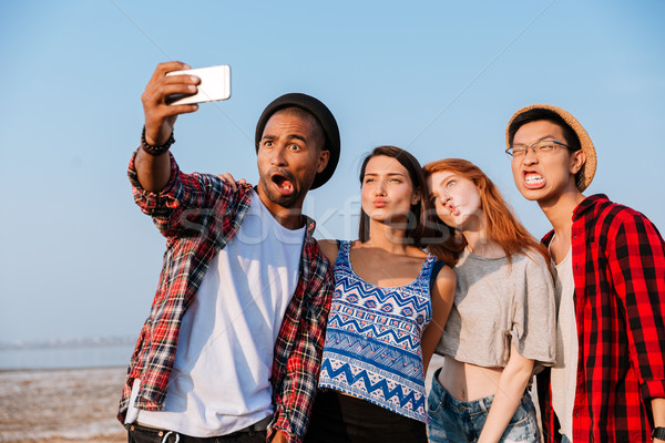 Stock photo: Friends taking selfie with cell phone and making funny faces