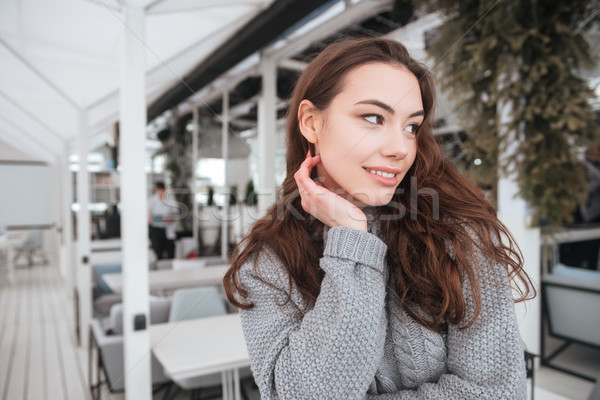 Pretty young lady dressed in sweater sitting in cafe Stock photo © deandrobot