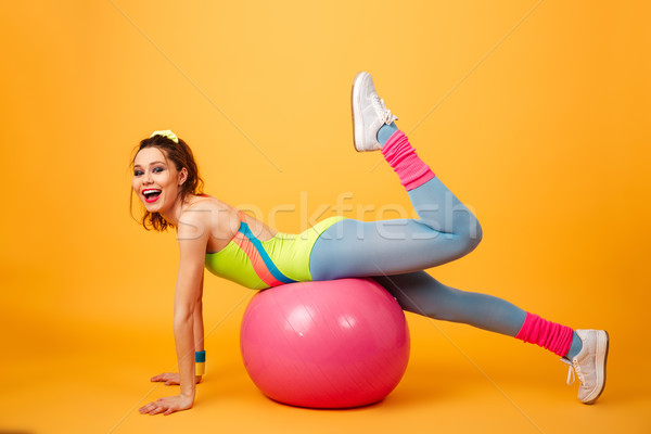 Sports woman posing over yellow background with fitness ball Stock photo © deandrobot