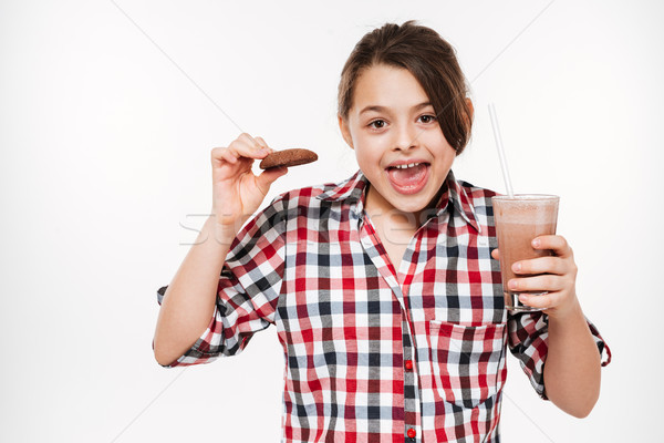 Happy young girl posing with cookie and cocoa Stock photo © deandrobot