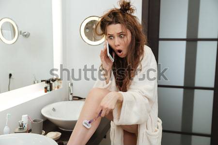Cheerful woman in bathrobe doing makeup at bathroom Stock photo © deandrobot