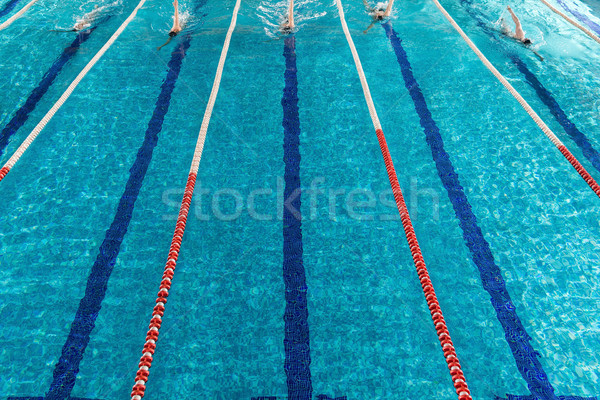 Five male swimmers racing against each other Stock photo © deandrobot