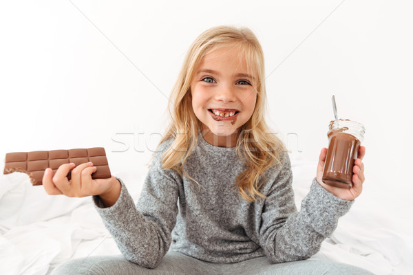 Cute funny girl holding chocolate bar and showing her dirty teet Stock photo © deandrobot