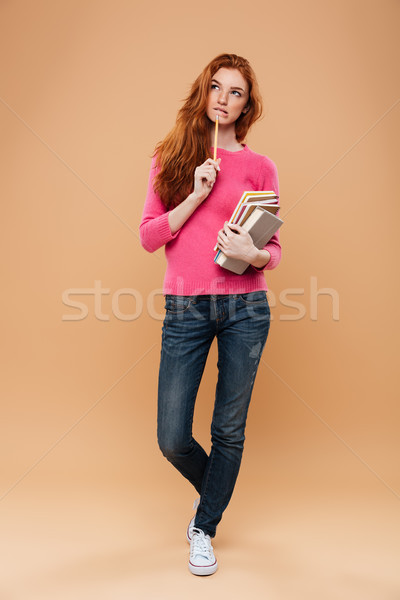 Full length portrait of a pensive pretty redhead girl Stock photo © deandrobot