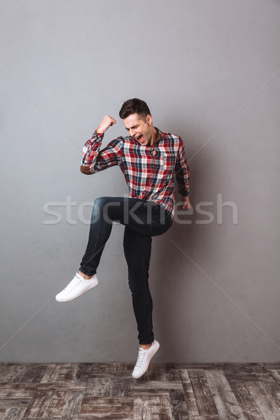 Full length image of Happy man in shirt and jeans Stock photo © deandrobot