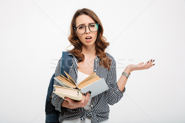 Confused young lady reading book Stock photo © deandrobot