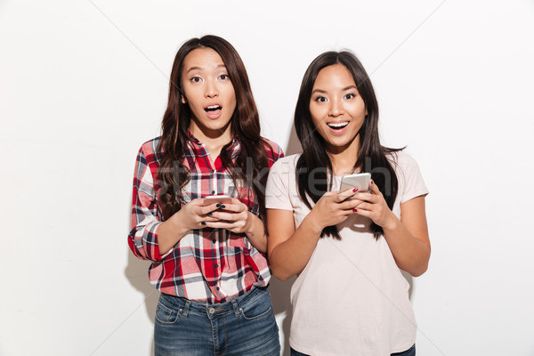 Asian surprised women sisters chatting Stock photo © deandrobot