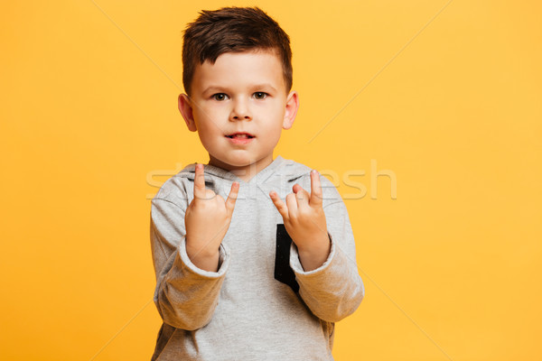 Cute boy child showing rock gesture. Stock photo © deandrobot