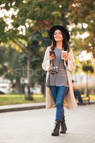 Modernen asian Frau halten Handy Kaffeetasse Stock foto © deandrobot