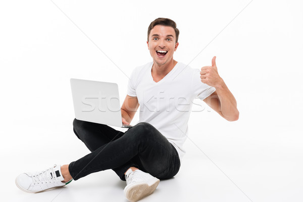 Stock photo: Portrait of a happy excited man holding laptop computer