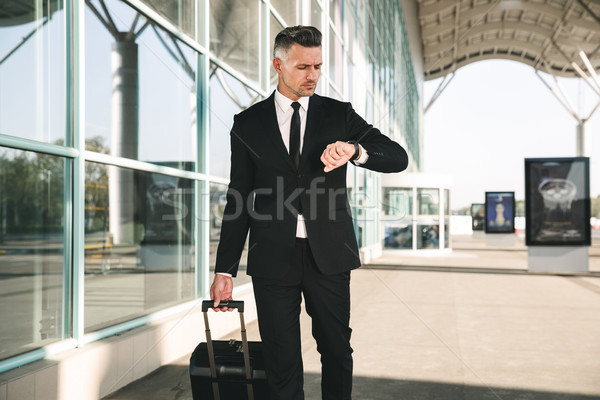 Ernstig zakenman pak lopen koffer buiten Stockfoto © deandrobot