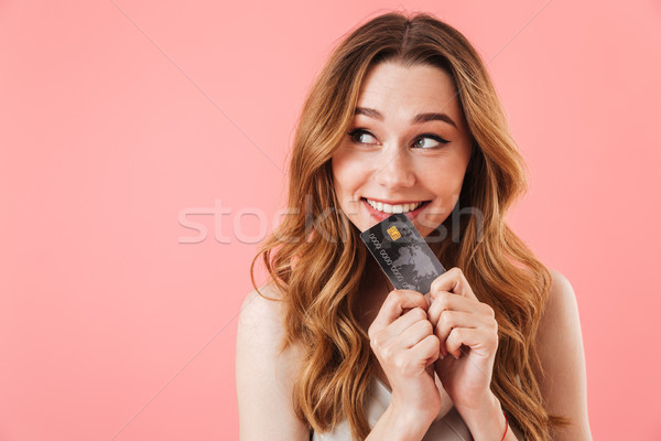 Pleased intrigued brunette woman in dress holding credit card Stock photo © deandrobot