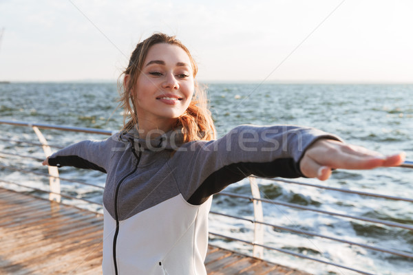 Boldog fiatal lány áll jóga póz tengerpart lány Stock fotó © deandrobot