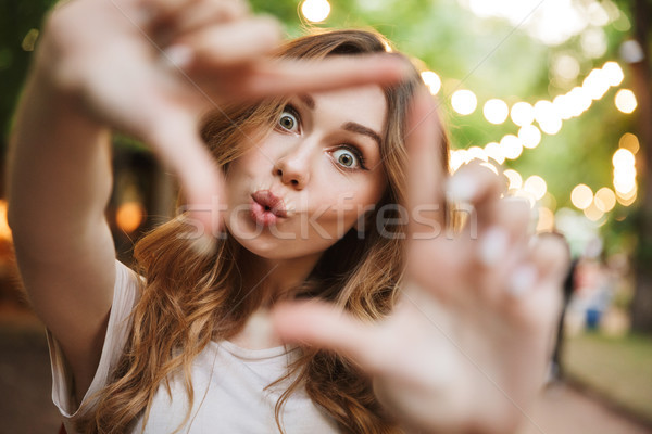 Close up of joyful young girl showing frame Stock photo © deandrobot