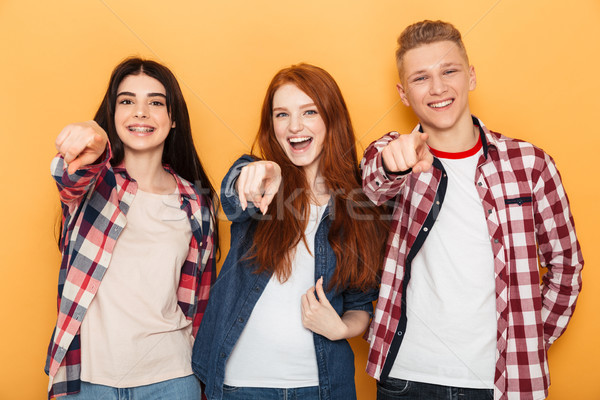 Group of happy school friends pointing fingers at camera Stock photo © deandrobot