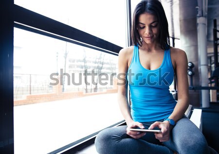 Smiling fit woman talking on the phone Stock photo © deandrobot