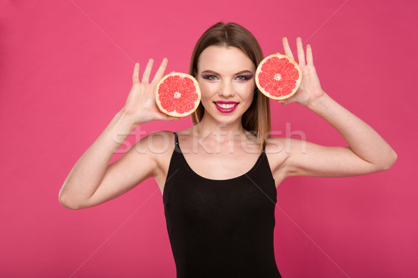 Happy smiling girl posing with two halves of grapefruit Stock photo © deandrobot