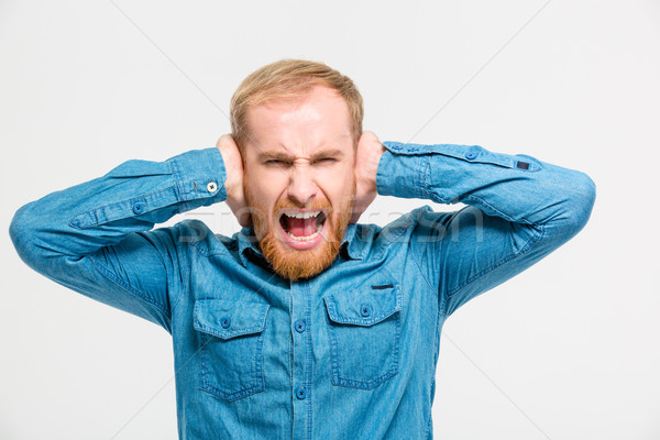 Mad hysterical man closed ears by hands and screaming Stock photo © deandrobot