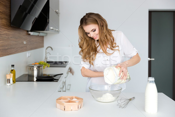 Feliz bastante mulher jovem em pé cozinhar branco Foto stock © deandrobot