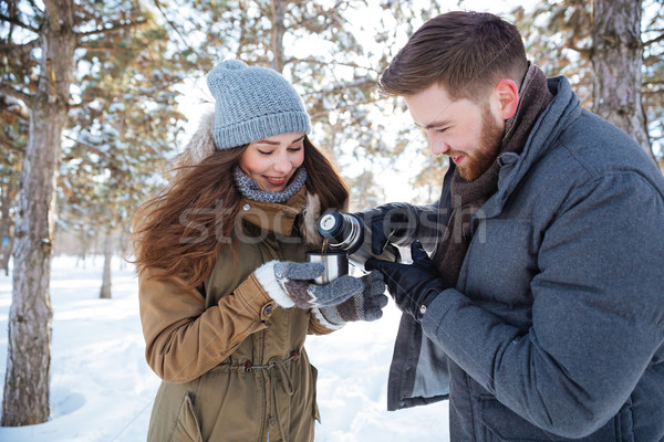 Happy couple drinking hot tea in winter park Stock photo © deandrobot