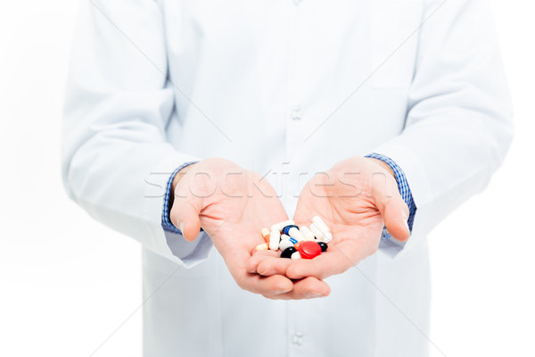 Male doctor holding pills  Stock photo © deandrobot