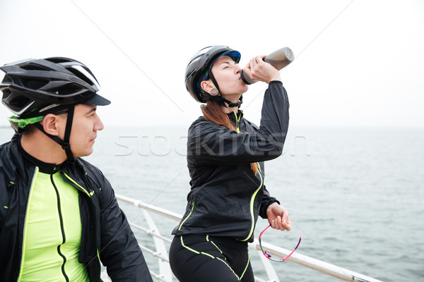 Kettő biciklisták pihen tenger nő ivóvíz Stock fotó © deandrobot