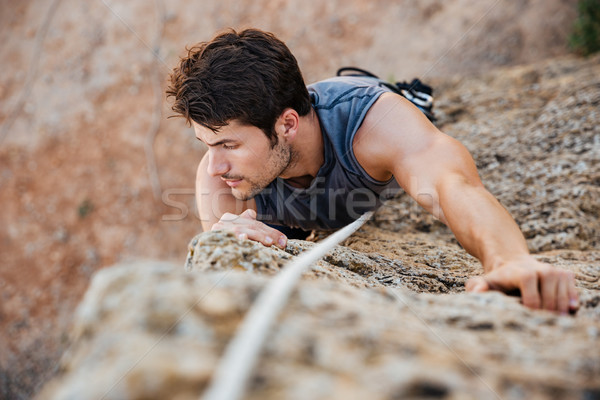 Man greep rock steil klif muur Stockfoto © deandrobot